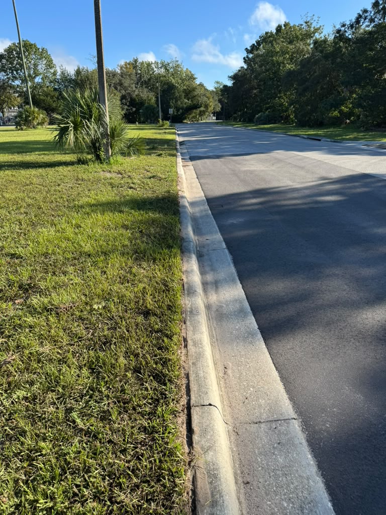 The same curb line cleanly edged and trimmed after service